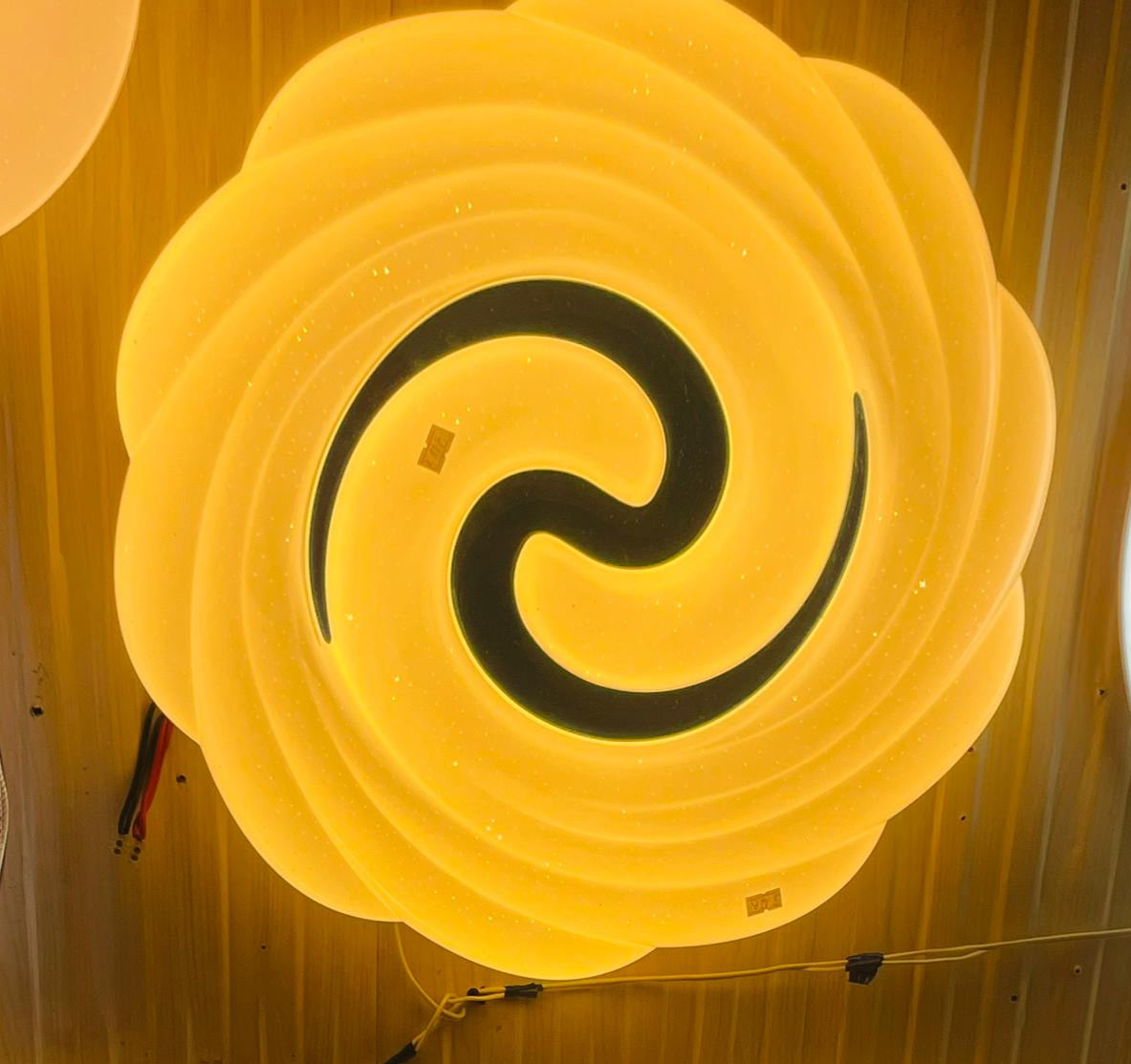 Teal swirl ceiling light featuring a unique circular design with a luminous glow