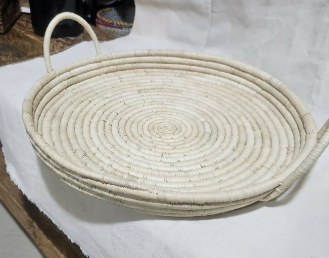 Woven basket with handles on a white surface