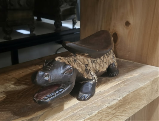 Wooden turtle figurine on a wooden surface with blurred background
